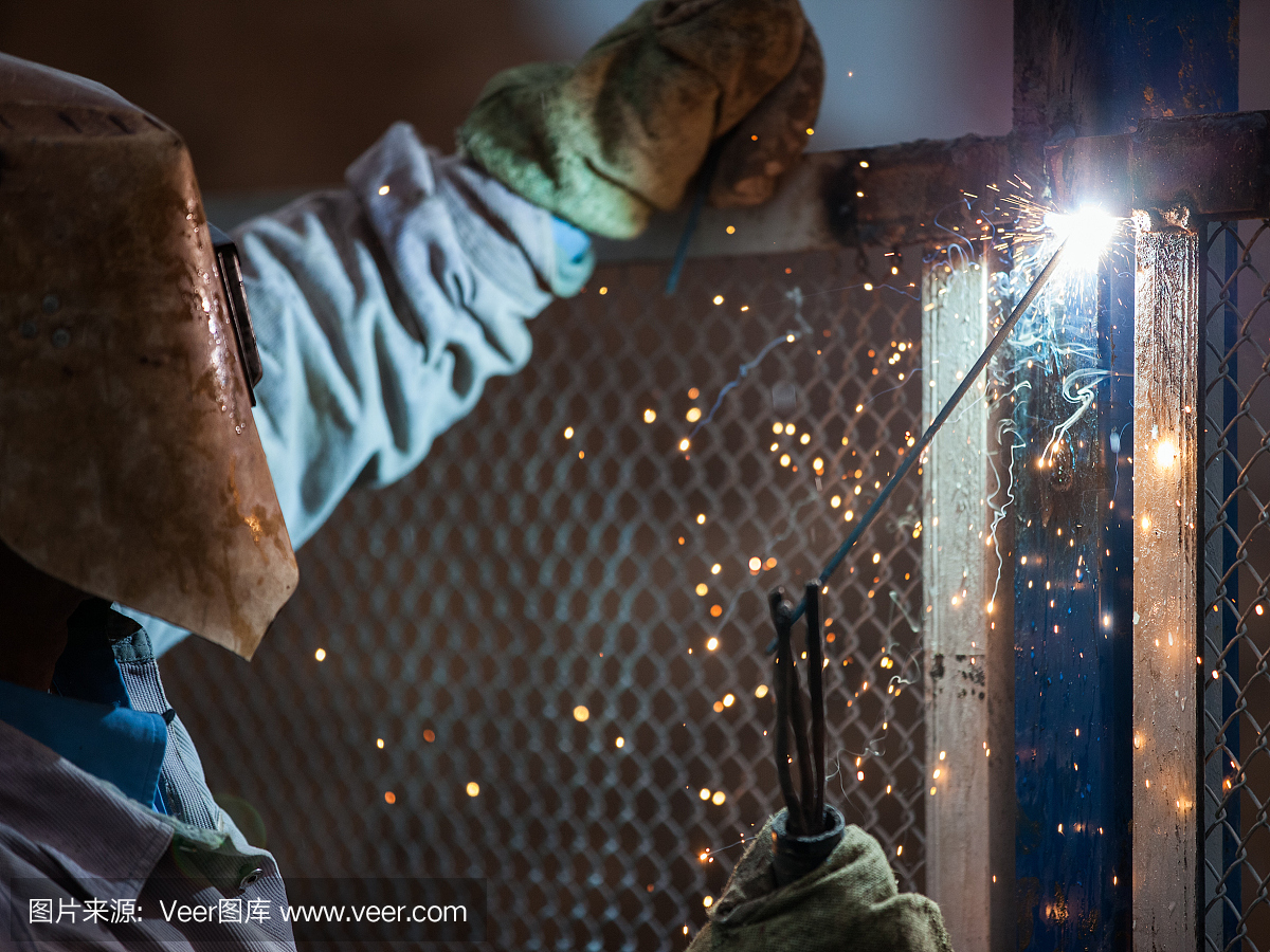 弧焊工人在保护面罩焊接金属结构